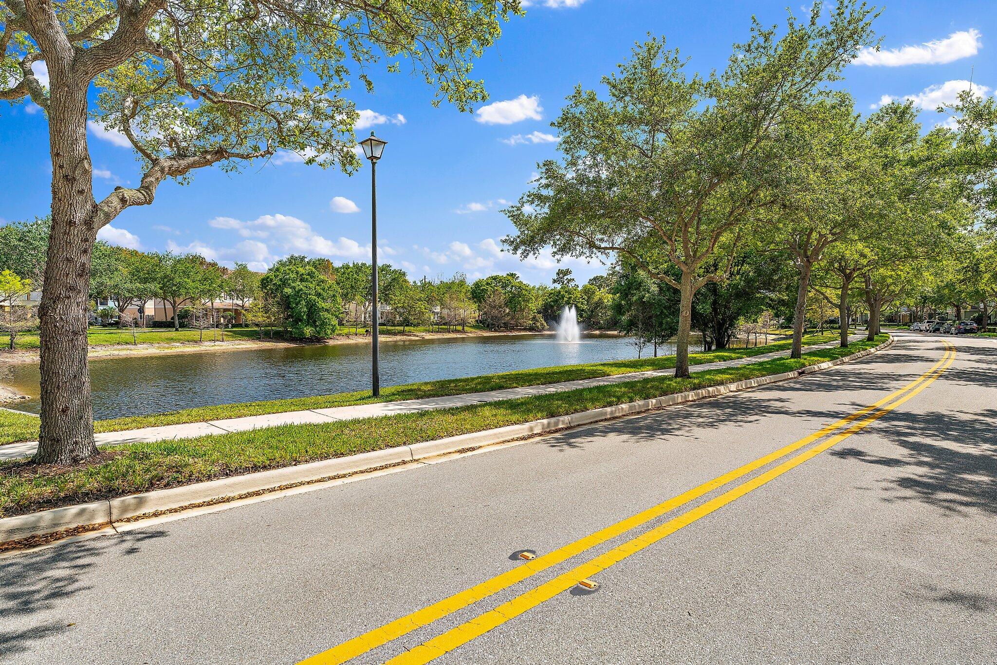 128 West Thatch Palm Circle Jupiter, FL 33458 - Photo 2 of 31 a view of a lake with a house and a big yard