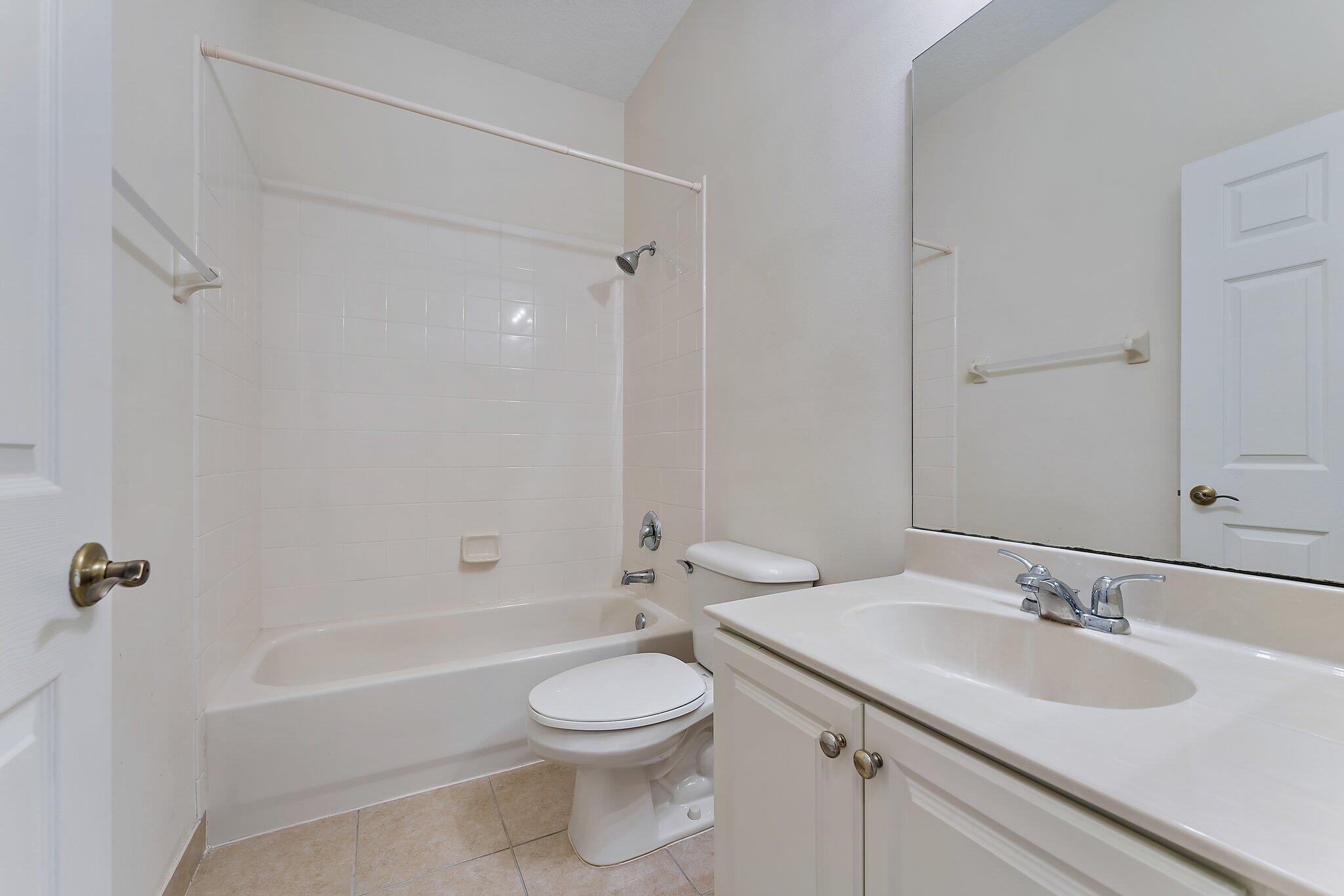 128 West Thatch Palm Circle Jupiter, FL 33458 - Photo 25 of 31 a bathroom with a toilet a sink a mirror a bathtub and vanity