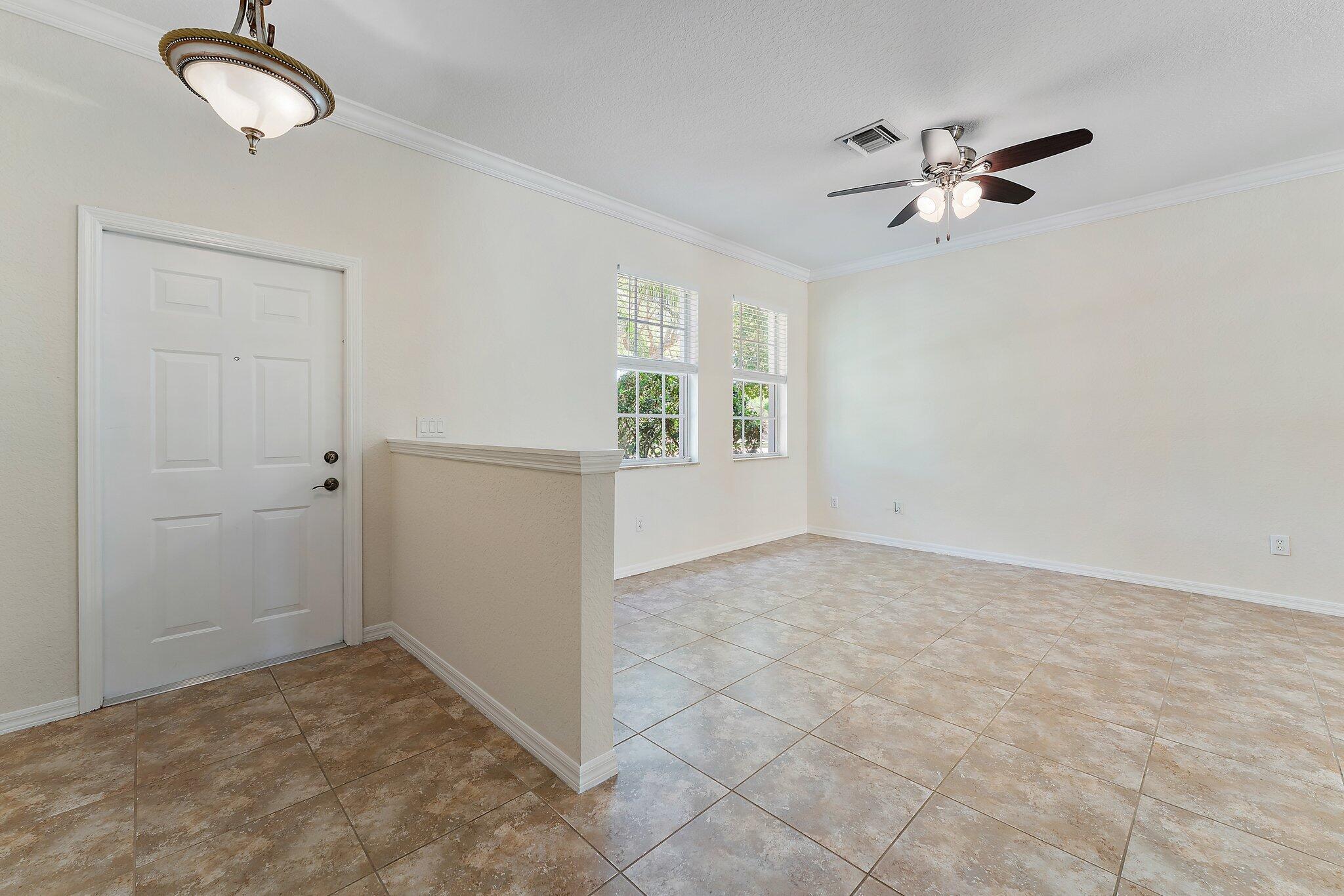 128 West Thatch Palm Circle Jupiter, FL 33458 - Photo 3 of 31 an empty room with windows and fan