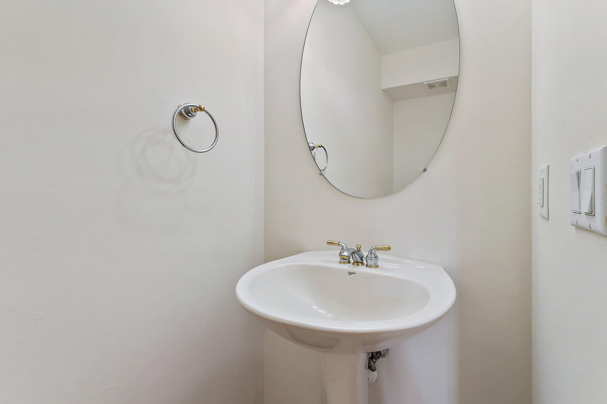 128 West Thatch Palm Circle Jupiter, FL 33458 - Photo 8 of 31 a bathroom with a sink a mirror and a lamp