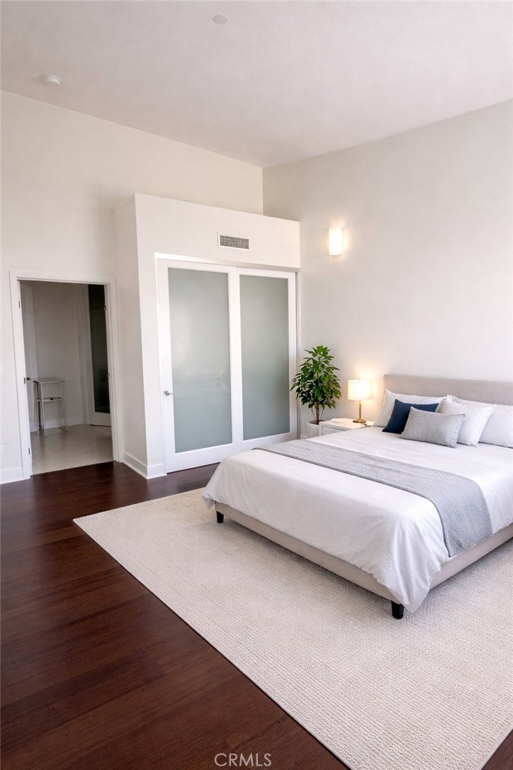 600 Ridgeley Drive Los Angeles, CA 90036 - Photo 12 of 29 a bedroom with a bed and wooden floor