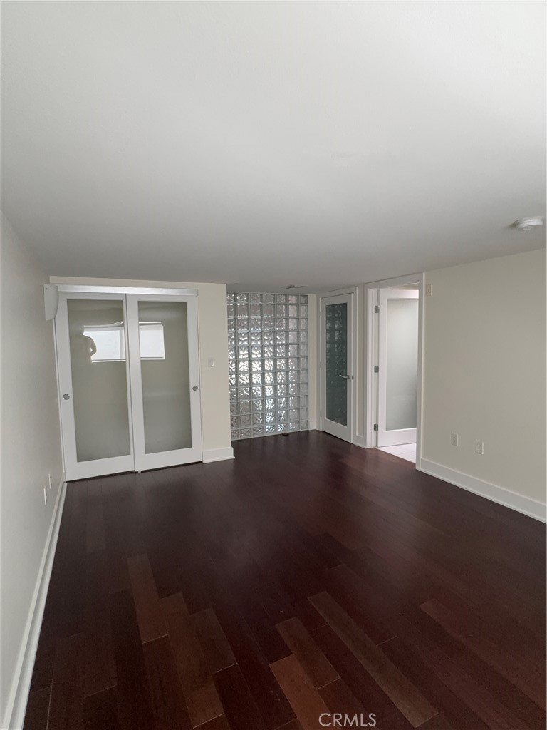 600 Ridgeley Drive Los Angeles, CA 90036 - Photo 19 of 29 an empty room with wooden floor and windows