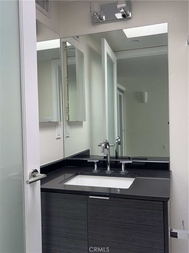 600 Ridgeley Drive Los Angeles, CA 90036 - Photo 22 of 29 a bathroom with a sink and a mirror