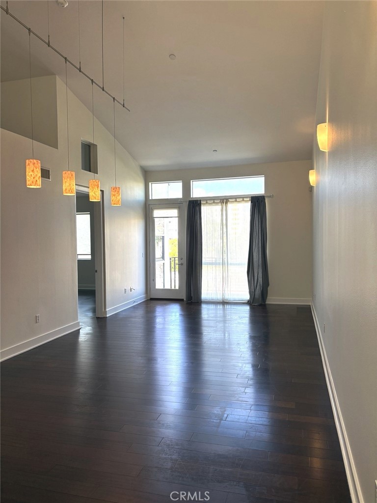 600 Ridgeley Drive Los Angeles, CA 90036 - Photo 3 of 29 an empty room with wooden floor and windows