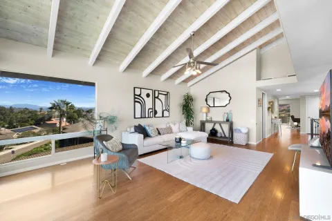 a living room with furniture wooden floor and a large window