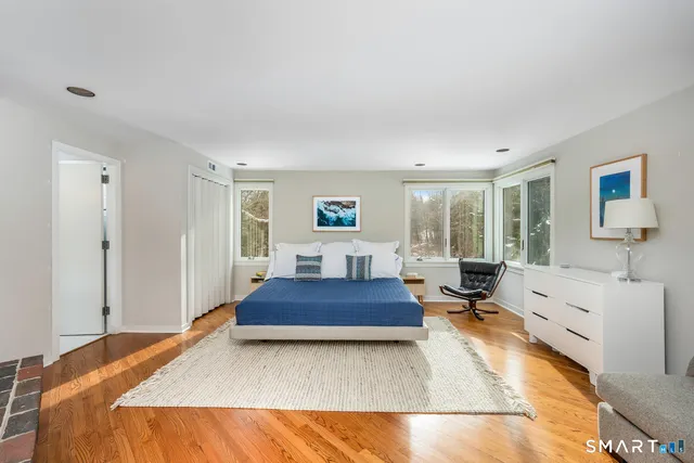 a spacious bedroom with a large bed a rug and windows
