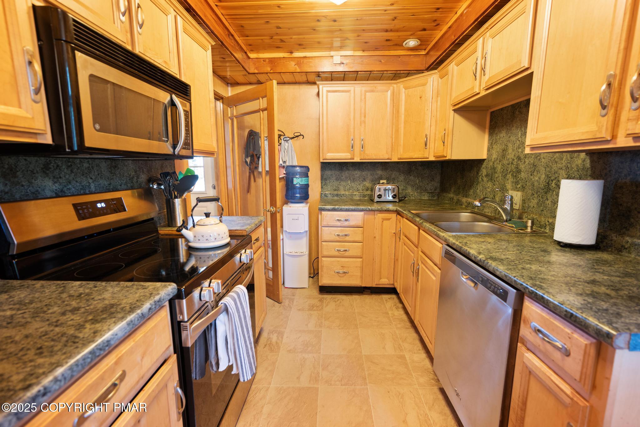165 Sweet Briar Road Pocono Pines, PA 18350 - Photo 13 of 39 a kitchen with stainless steel appliances granite countertop a stove a sink and a microwave