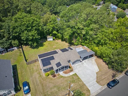 an aerial view of a house with swimming pool and large trees