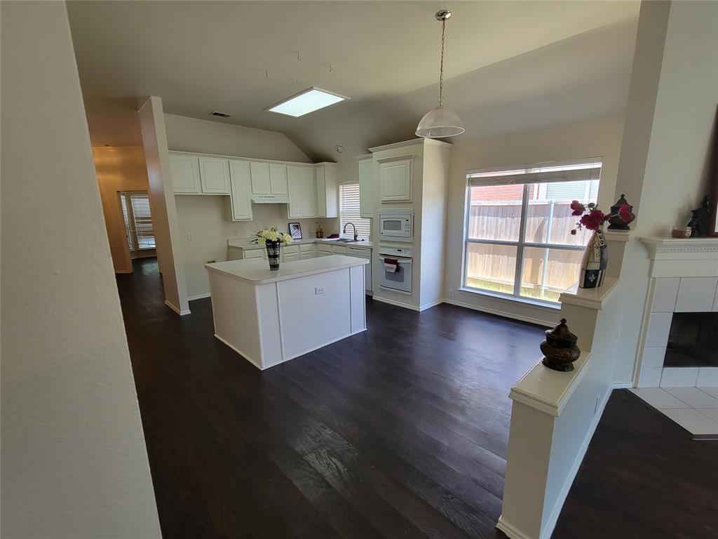 2913 Rush Creek Road McKinney, TX 75072 - Photo 26 of 32 Kitchen featuring white cabinets, dark wood-type flooring, and a center island open to breakfast room and open hallway