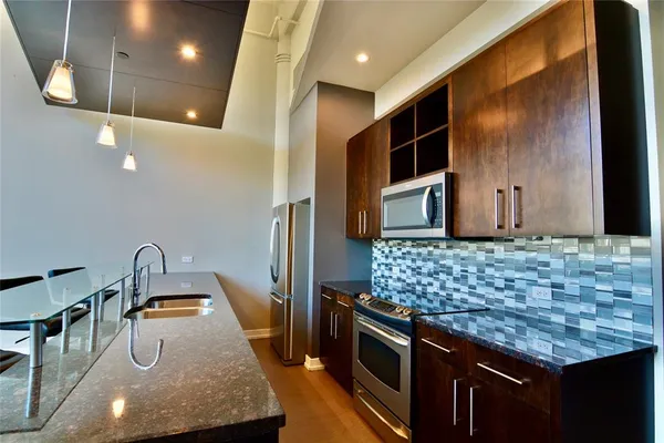 a kitchen with stainless steel appliances kitchen island granite countertop a stove a sink and a microwave