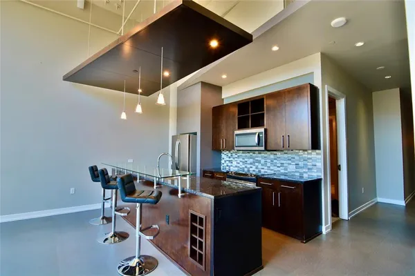 a view of kitchen with granite countertop window and refrigerator