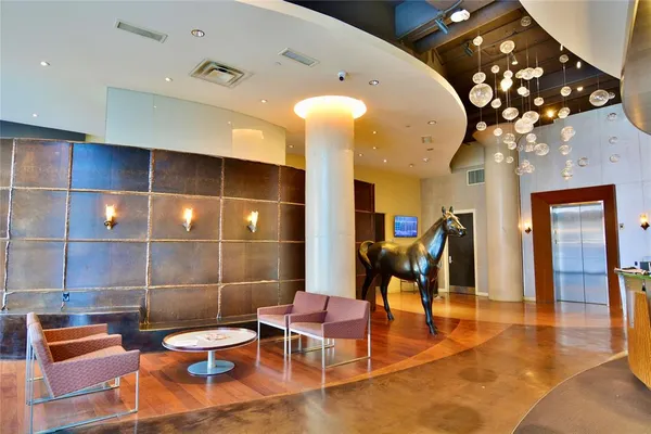 a lobby with furniture and chandelier