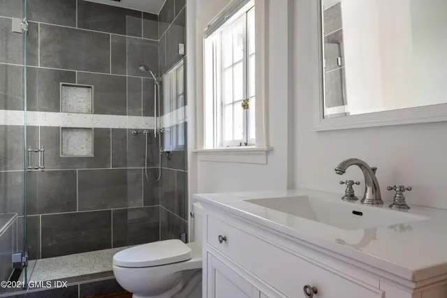 a bathroom with a sink a toilet and a mirror