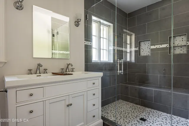 a bathroom with a tub a sink and a large window