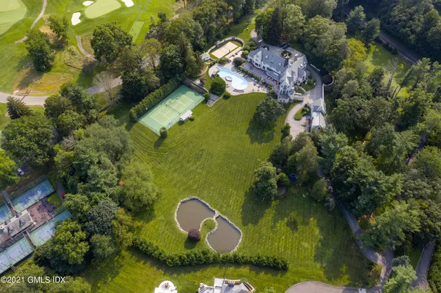 an aerial view of a house with swimming pool and green space