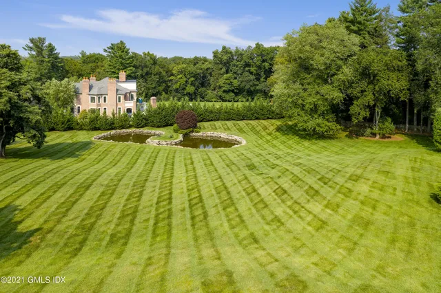 a view of a house with garden and a sitting area