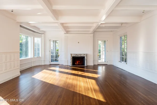 a view of an empty room with window and fire place