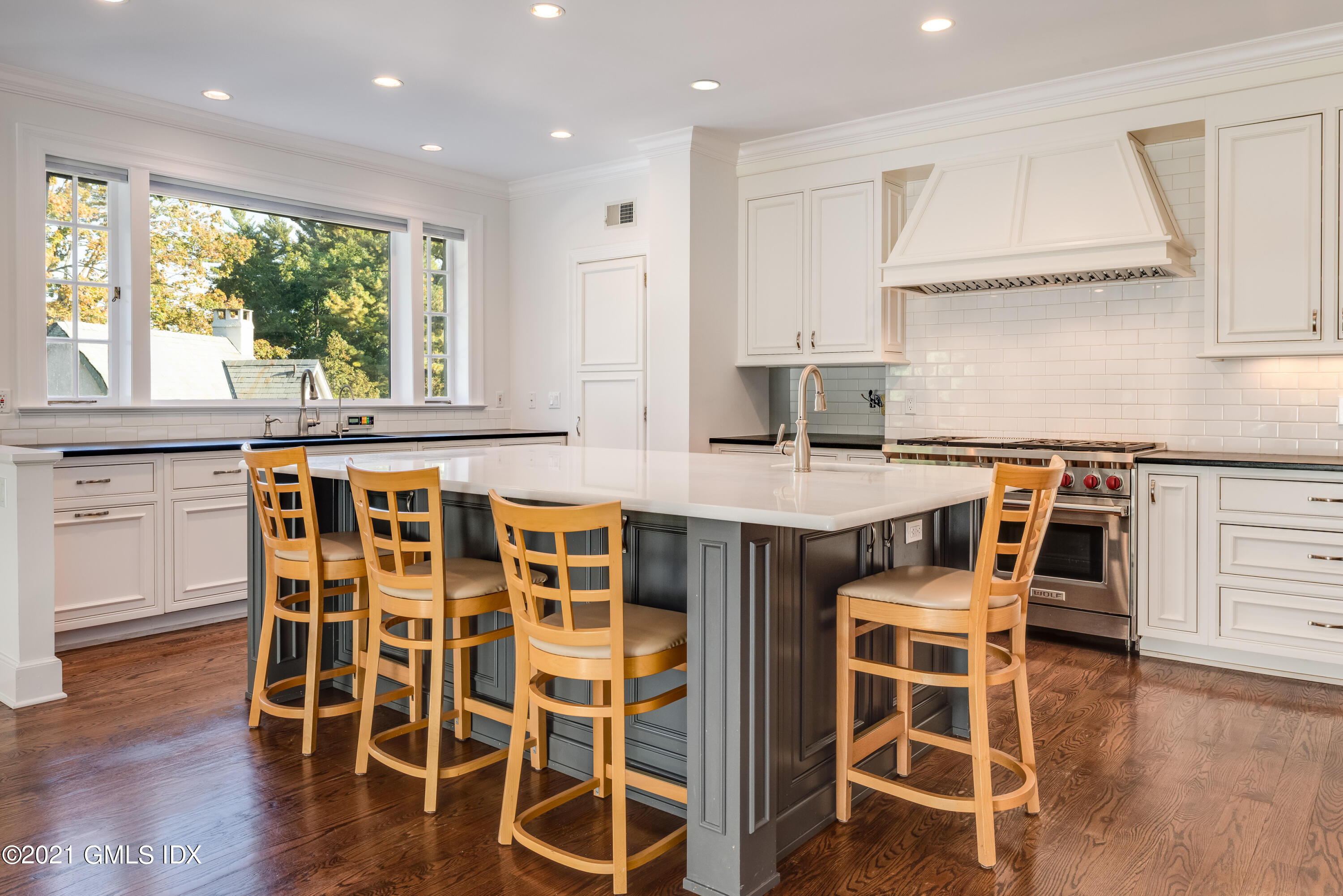 25 Doubling Road Greenwich, CT 06830 - Photo 10 of 30 a kitchen with stainless steel appliances granite countertop a stove top oven a sink with island and chairs in it