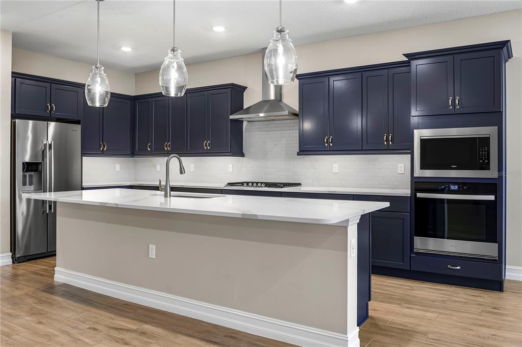 4474 Northwest 53rd Avenue Road Ocala, FL 34480 - Photo 15 of 78 a kitchen with stainless steel appliances granite countertop a sink a stove and a refrigerator with wooden floor