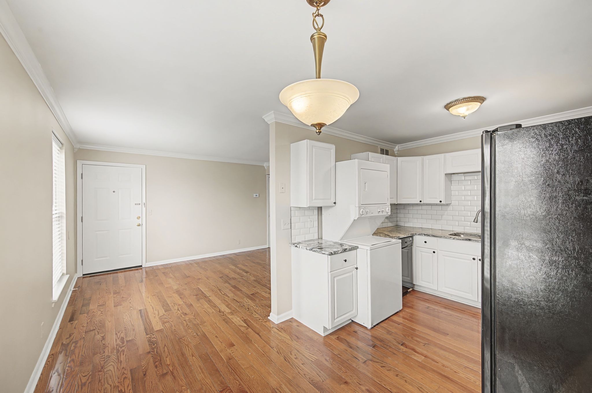 1011 Murfreesboro Road, Unit L10 Franklin, TN 37064 - Photo 15 of 47 a kitchen with white cabinets and wooden floor