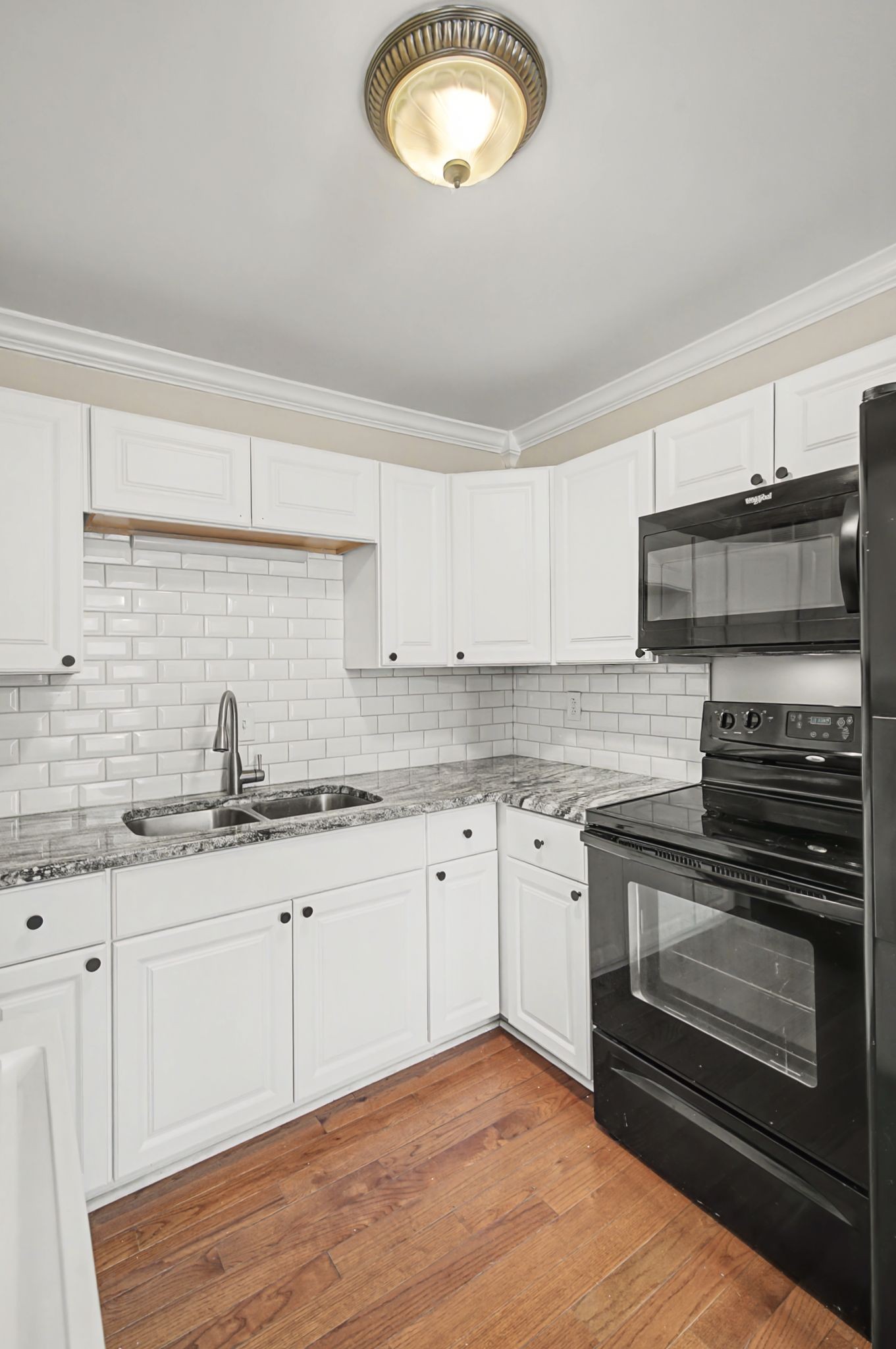 1011 Murfreesboro Road, Unit L10 Franklin, TN 37064 - Photo 19 of 47 a kitchen with granite countertop a stove sink and cabinets