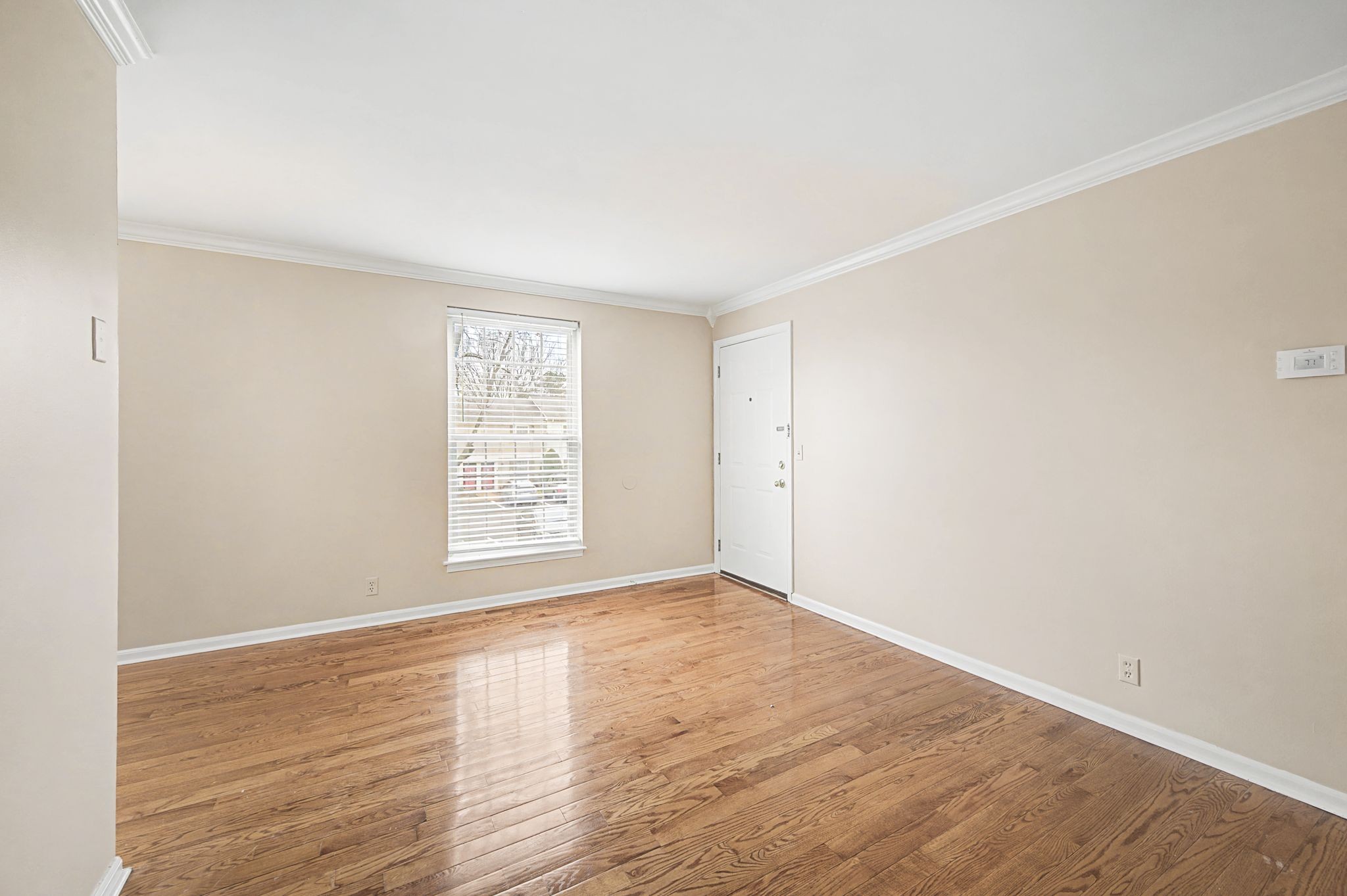 1011 Murfreesboro Road, Unit L10 Franklin, TN 37064 - Photo 10 of 47 a view of an empty room with wooden floor and a window