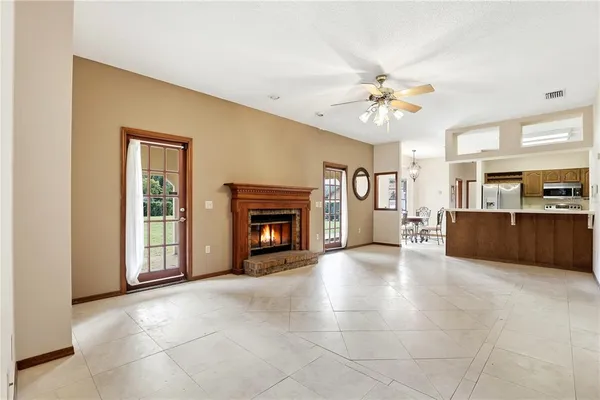 a view of kitchen with stainless steel appliances granite countertop a stove and a refrigerator with cabinets