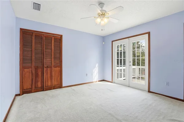 an empty room with a window and a ceiling fan