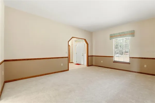 a view of an empty room with a fireplace and a window
