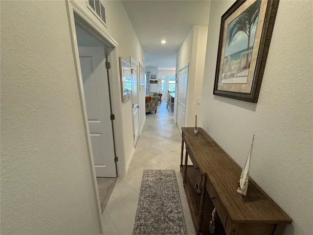 a view of hallway with mirror and wooden floor