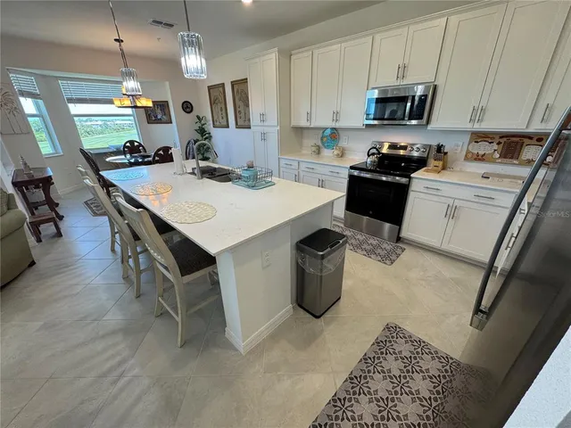 a kitchen with a sink a stove and chairs
