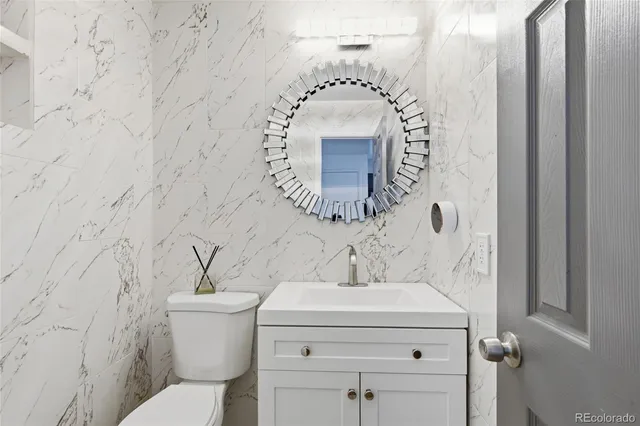 a bathroom with a sink and mirror with toilet