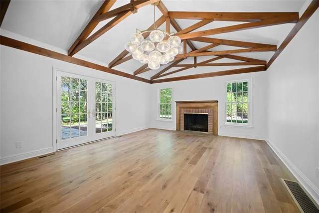 a view of empty room with wooden floor and fireplace