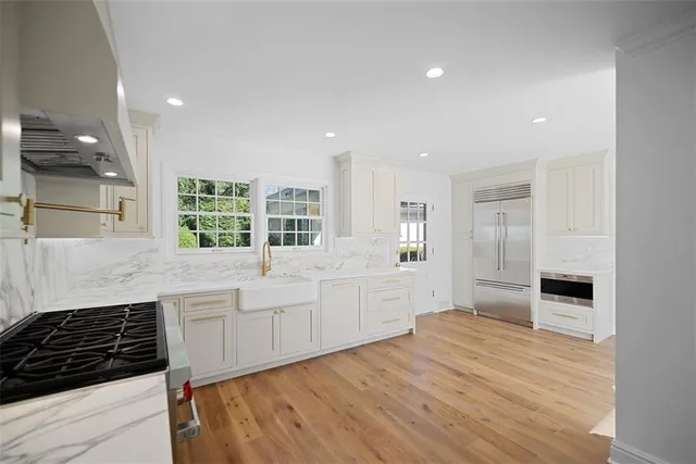a large kitchen with stainless steel appliances granite countertop a stove and a sink