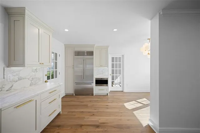 a large white kitchen with a sink and dishwasher with wooden floor