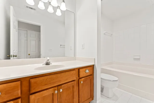 an empty room with windows and ceiling fan