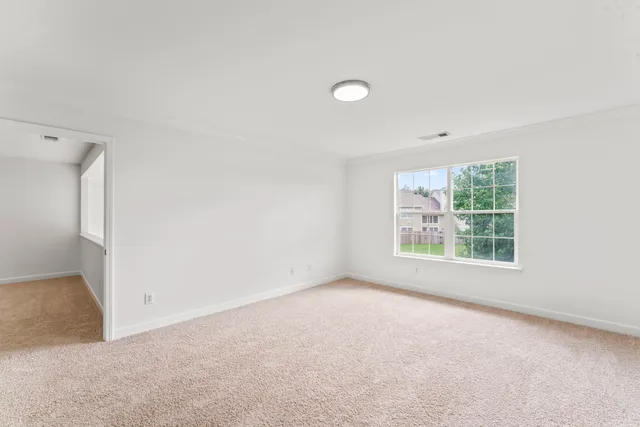 a view of a backyard with a large tree and wooden fence