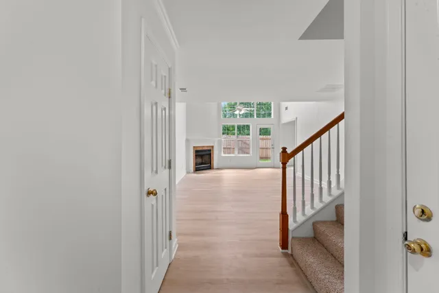 a view of a hallway with wooden floor and staircase