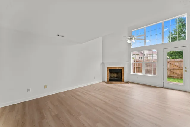 a view of an empty room with a window and fireplace