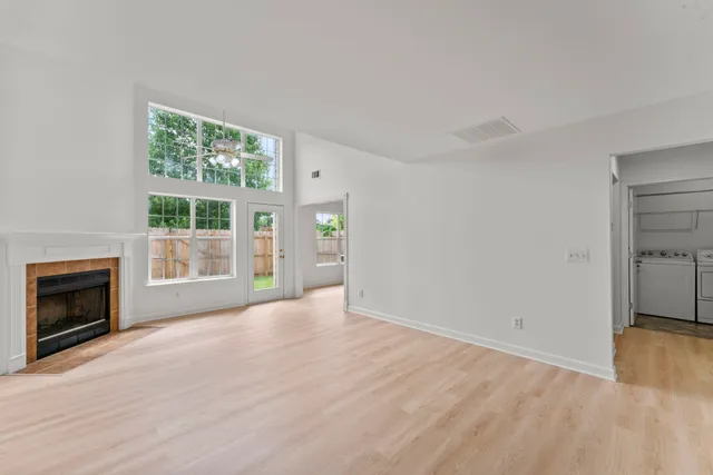 a view of an empty room with a fireplace and a window