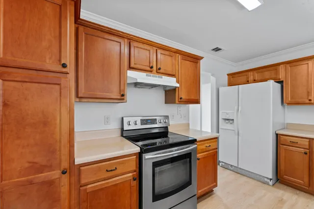 a kitchen with stainless steel appliances granite countertop a refrigerator and a stove top oven