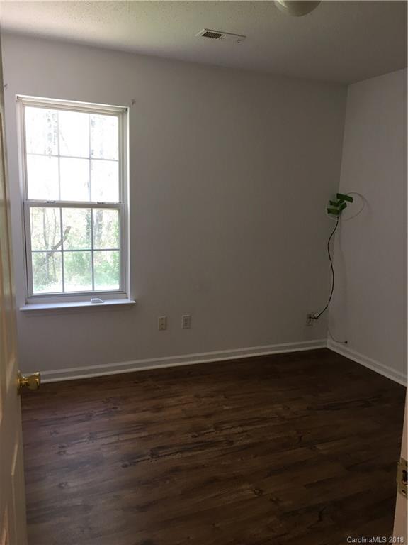 4306 Lothar Ridge Lane Charlotte, NC 28216 - Photo 16 of 22 an empty room with wooden floor and windows