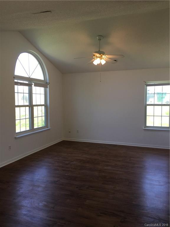 4306 Lothar Ridge Lane Charlotte, NC 28216 - Photo 8 of 22 an empty room with wooden floor chandelier and windows