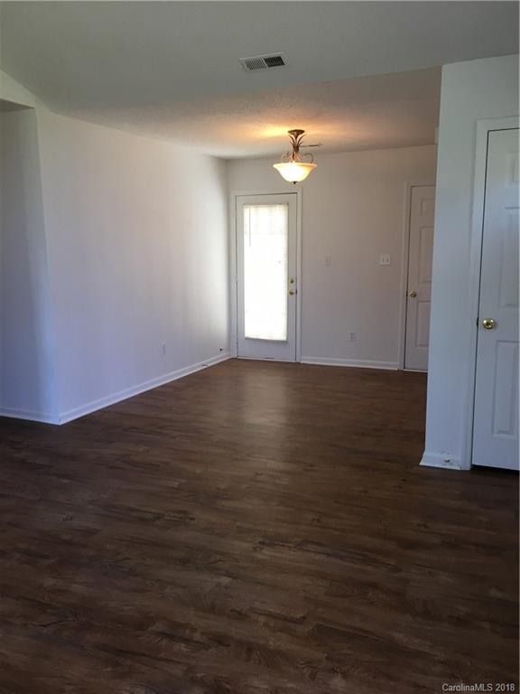 4306 Lothar Ridge Lane Charlotte, NC 28216 - Photo 9 of 22 a view of an empty room with wooden floor and a window
