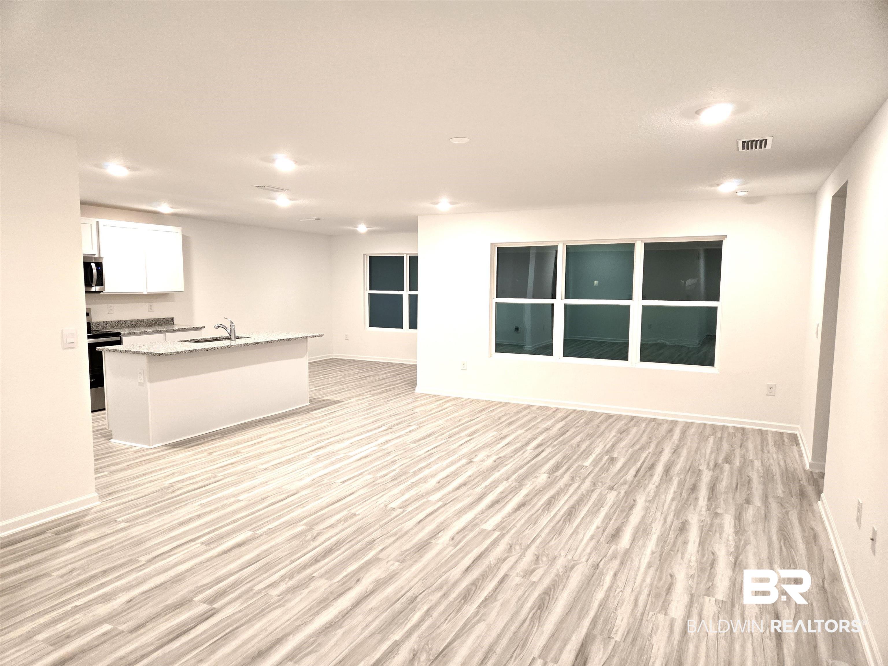 24385 Ringneck Loop Elberta, AL 36530 - Photo 6 of 33 Unfurnished living room with light hardwood / wood-style floors and sink