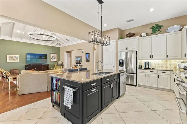 a living room with furniture a dining table and a chandelier