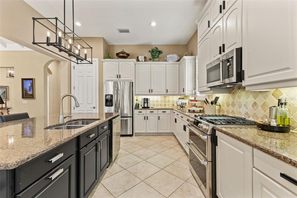4978 Southern Valley Loop Brooksville, FL 34601 - Photo 14 of 78 a kitchen with stainless steel appliances granite countertop a sink a stove and cabinets