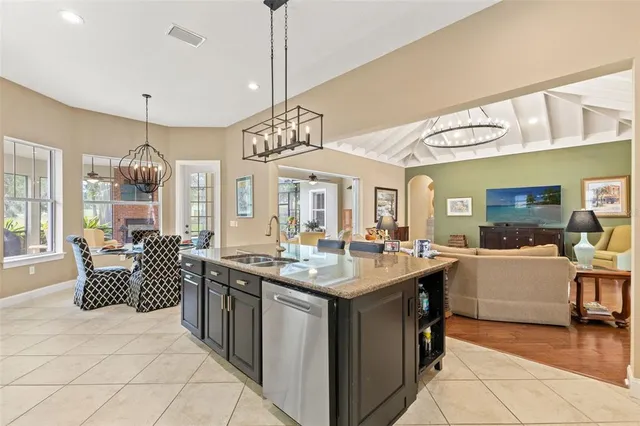 a living room with furniture a chandelier and a wooden floor