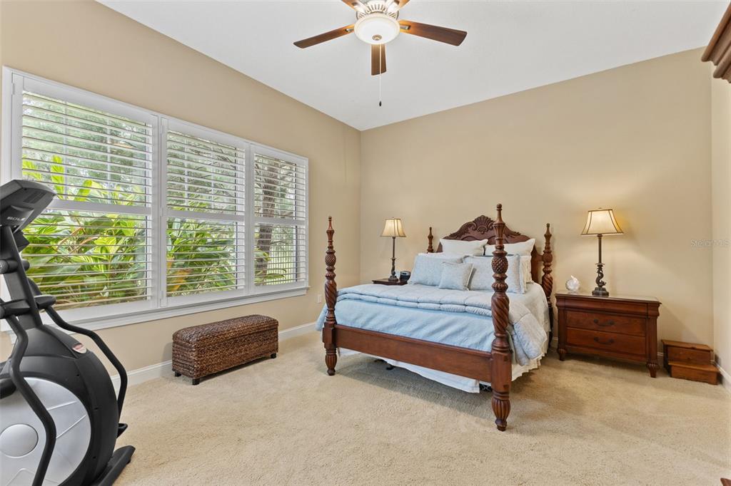 4978 Southern Valley Loop Brooksville, FL 34601 - Photo 30 of 78 a spacious bedroom with a bed and a chandelier