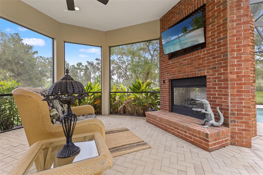 4978 Southern Valley Loop Brooksville, FL 34601 - Photo 39 of 78 a living room with couches a fireplace and a large window with garden view